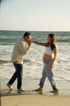 a man and woman walking along the beach