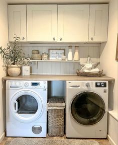 a washer and dryer in a small room with white cabinets on the wall