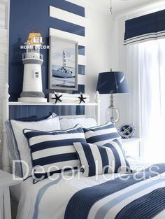 a bedroom with blue and white striped bedding in the corner, along with a framed lighthouse on the wall