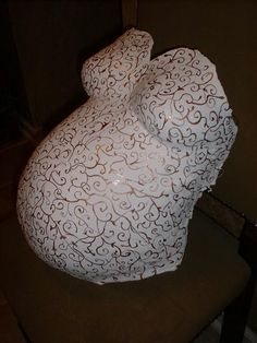 a large white vase sitting on top of a chair