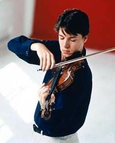 a young man is playing the violin