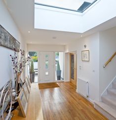 an empty room with wooden floors and skylight above the door, is shown in this image