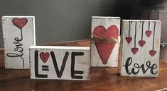 three wooden blocks with hearts and the words love are tied to each other on a table