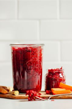 a jar filled with cranberry sauce next to sliced carrots and other fruits