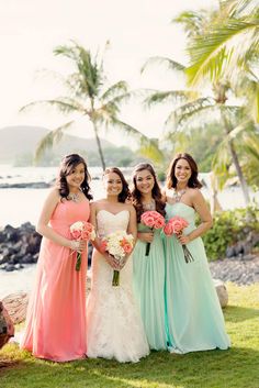 four bridesmaids pose for a photo in front of the ocean and palm trees