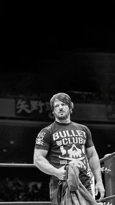 black and white photograph of a man holding a baseball bat in his hand while wearing a bullee t - shirt