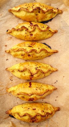 four pieces of bread sitting on top of a piece of parchment covered in burnt paper