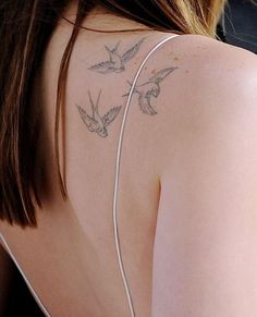 the back of a woman's shoulder with birds on it