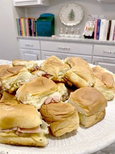 a white plate topped with sandwiches on top of a counter next to a book shelf