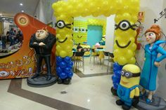 some balloons that are in the shape of minionsettes and one is wearing a blue suit