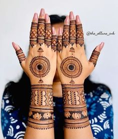 a woman's hands with henna tattoos on them