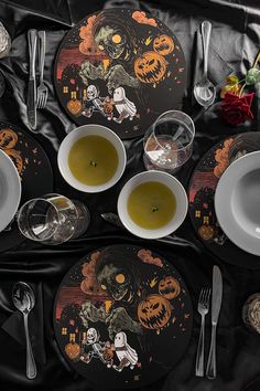 a table set for halloween with plates and silverware