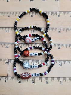 Get your one-of-a-kind, pretty, little thing from Doohickies & Such.  Sign up for the VIP newsletter to get insider news before anyone else! http://eepurl.com/hdVZk9  This is a great gift for the sports mom. Personalize your child's sport team with the sport ball of choice. Each bracelet will say MOM unless you prefer to change. If so, please message me or leave me a note at checkout.  Customize the bracelet to the colors of the team. These would make great fundraising bracelets! Measuring 7.25" and is stretchy, made with double 0.5mm stretch cord.  If you would like a different size than the standard size, please message me or leave a note with your order.  Make sure to leave me a note for the colors you would like your bracelet(s).  Made with love and from a smoke free home. WEAR AND CAR Beaded Sports Bracelets, School Bracelet Ideas, Adjustable Multicolor Sporty Bracelets, Sporty Adjustable Stretch Bracelet As Gift, Adjustable Sporty Stretch Bracelet Gift, Sporty Adjustable Beaded Jewelry, Personalized Black Sporty Bracelets, Sporty Personalized Black Bracelet, Sporty Personalized Black Bracelets