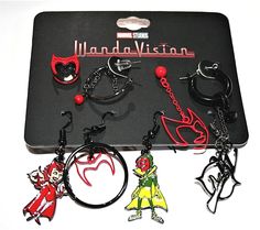 several different key chains and charms on a black tray