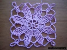 a crocheted doily on a wooden surface