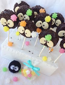 chocolate cake pops with gummy bears on them sitting on a white plate next to a black sheep