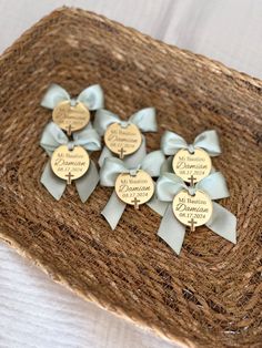 six personalized gold and silver heart shaped pins on a rafter with blue bows