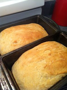 two loafs of bread sitting on top of pans in the oven, ready to be baked