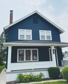 a blue house with white trim on the front and side of it's roof