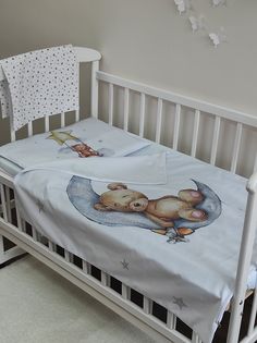 a baby crib with a teddy bear blanket on it