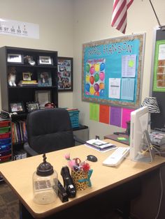 an office with a desk, chair and bulletin board on the wall in front of it