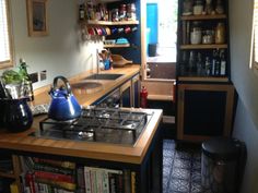 a kitchen with a stove top oven next to a counter filled with pots and pans