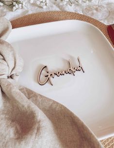 the word grandpa spelled in cursive wood letters on a white plate with flowers