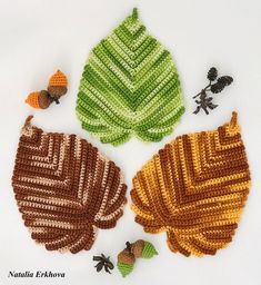 crocheted leaves and acorns are arranged on a white surface