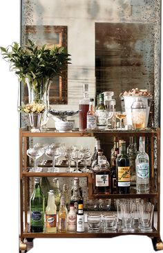 a bar cart filled with lots of bottles and glasses