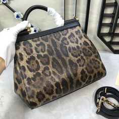 Dolce & Gabbana Leopard Print Medium Sicily Top Handle Bag Muticolour For Women 9.8in/25cm DG Rep 1:1 Size: 25 x 20 x 12 cm / 9.8 x 7.9 x 4.7 inches (Length x Width x Height) This gorgeous leopard print Sicily satchel from Dolce & Gabbana is a handbag coveted by women around the world. It has a well-structured design and a flap that opens to a compartment with fabric lining and enough space to fit your essentials. The bag comes with gold-tone hardware, a top handle, a detachable shoulder Louis Vuitton Shirt, Structured Design, Dog Bag, Evening Clutch Bag, Handle Bag, Tote Backpack, Sicily, Fashion Handbags, Top Handle