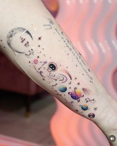 a person with a tattoo on their arm that has planets and stars all over it