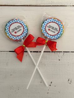 two candy lollipops with red bows on them