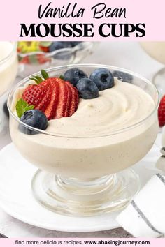 a dessert with strawberries and blueberries in a glass bowl on a white plate