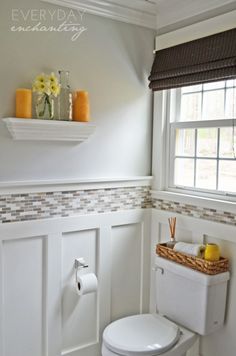 a white toilet sitting in a bathroom next to a window with yellow flowers on it