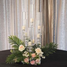 a centerpiece with candles and flowers on a table