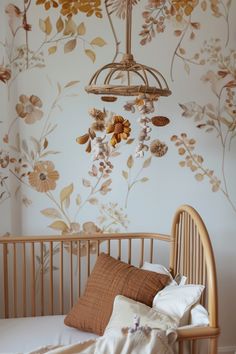 a baby crib in front of a wall with flowers and leaves painted on it