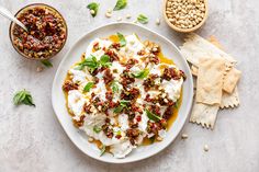 a white plate topped with food next to crackers