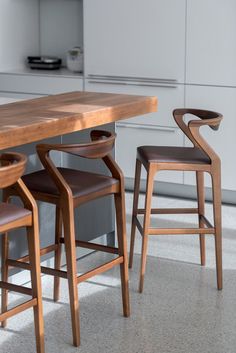 two wooden chairs sitting at a table in a kitchen