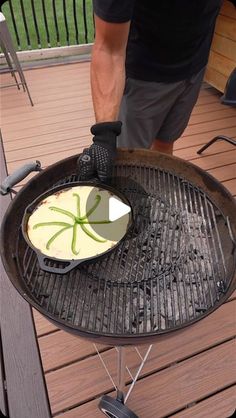 a man grilling food on top of an outdoor grill