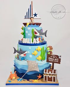 a three tiered cake decorated with blue and white fondant, under the sea theme