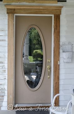 the front door to a house with a large oval mirror on it's side