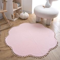 a pink rug with pom - poms on the floor in a child's room