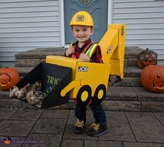 a little boy in a construction truck costume