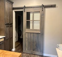 an open door leading to a kitchen with wooden cabinets