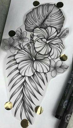 a drawing of flowers and leaves on paper with gold circles around the edges, next to a marker pen