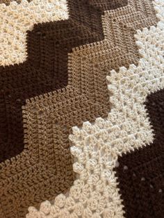 a crocheted blanket is laying on the floor