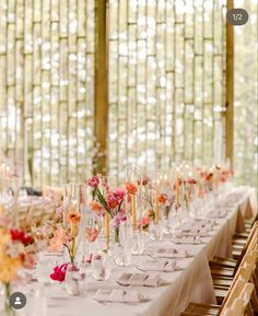 a long table is set up with flowers and wine glasses for an elegant wedding reception