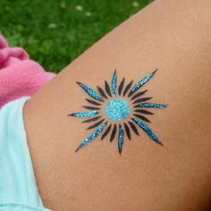 a woman's arm with blue glitter tattoos on it