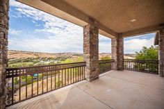 a balcony with stone pillars and railings overlooks the valley in front of it