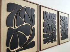 three black and white paintings hanging on the wall